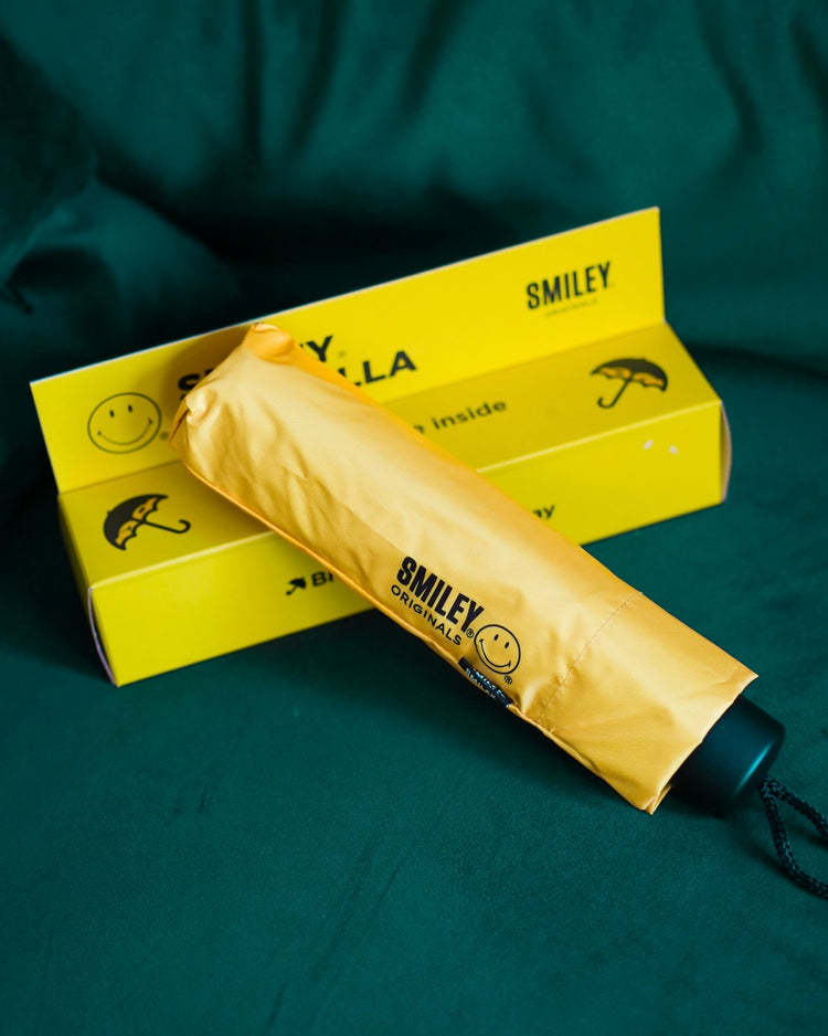 Parapluie Smiley ouvert, motif joyeux à l'intérieur.