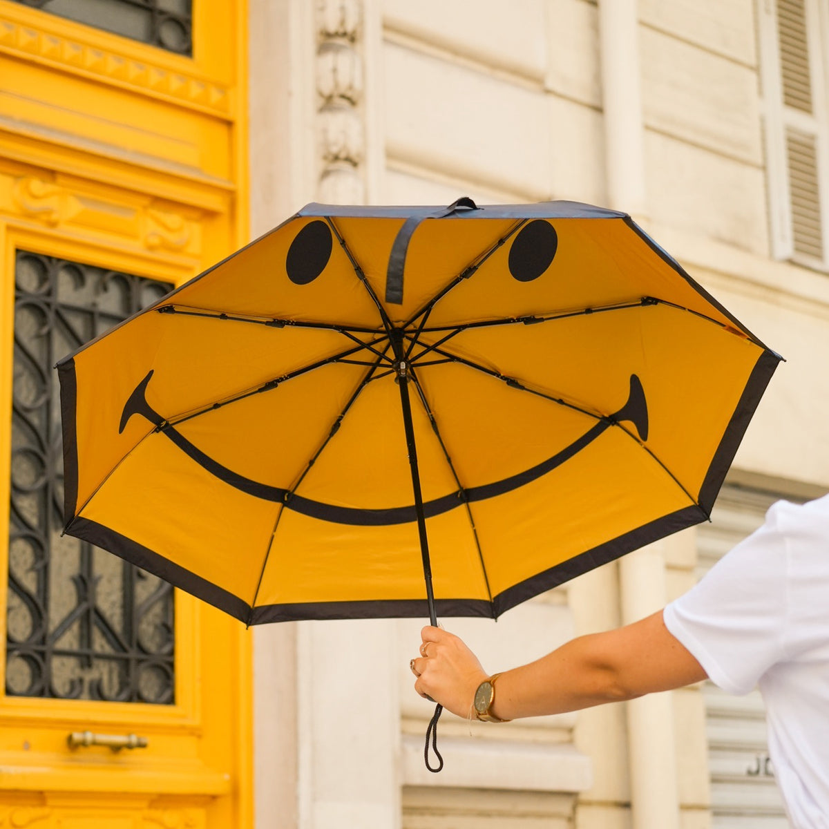 Parapluie Smiley ouvert, motif joyeux à l'intérieur.