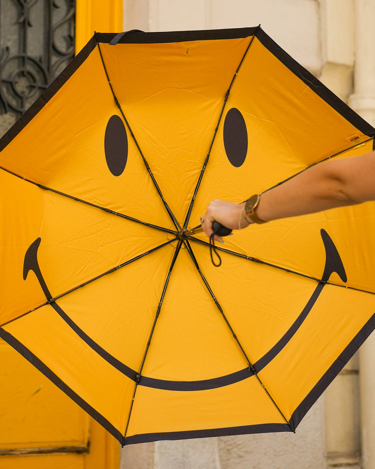 Parapluie Smiley ouvert, motif joyeux à l'intérieur.
