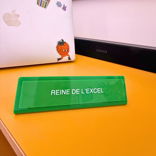 Plaque de bureau verte 'Reine de l'excel' sur un bureau