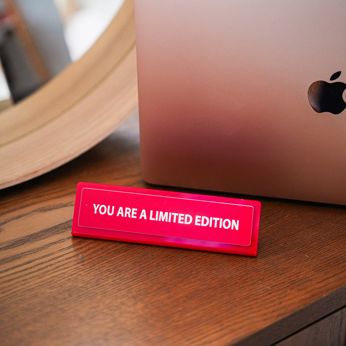 Plaque de bureau humoristique avec message en lettres blanches.
