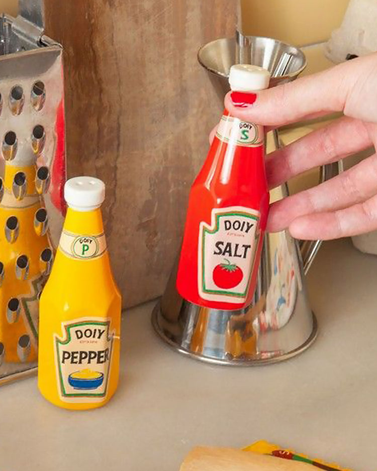Salière et poivrière en forme de bouteilles de sauces vintage.