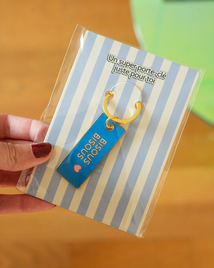 Porte-clé Bisous bisous avec cœur en relief et détails colorés.