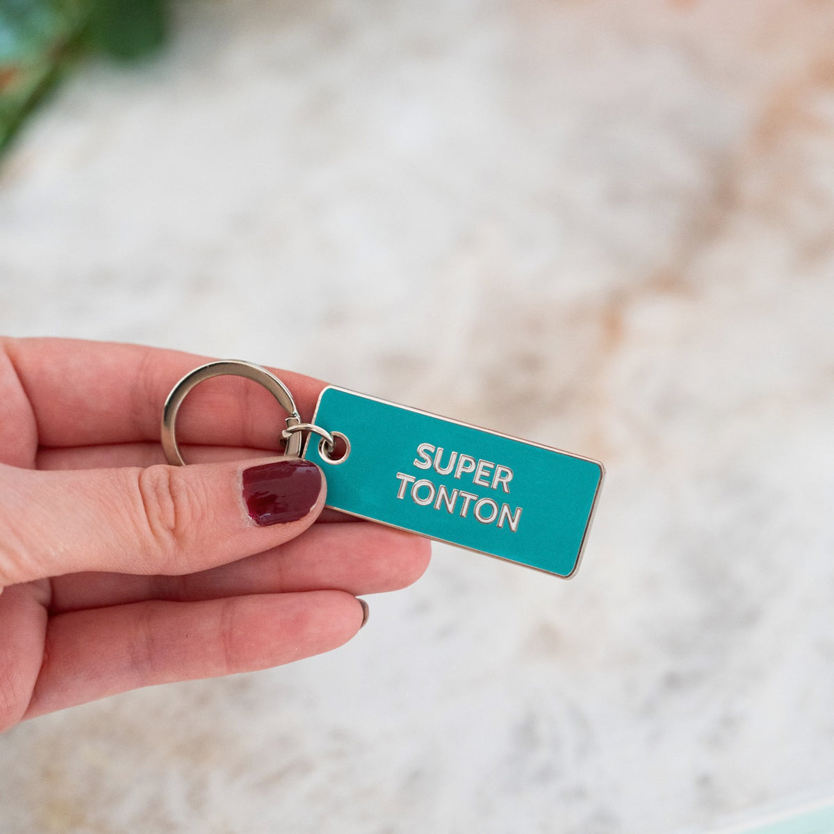 Porte-clé Super Tonton avec un design humoristique et coloré.