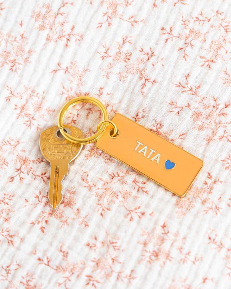Porte-clé Tata avec un design coloré et un cœur stylisé.