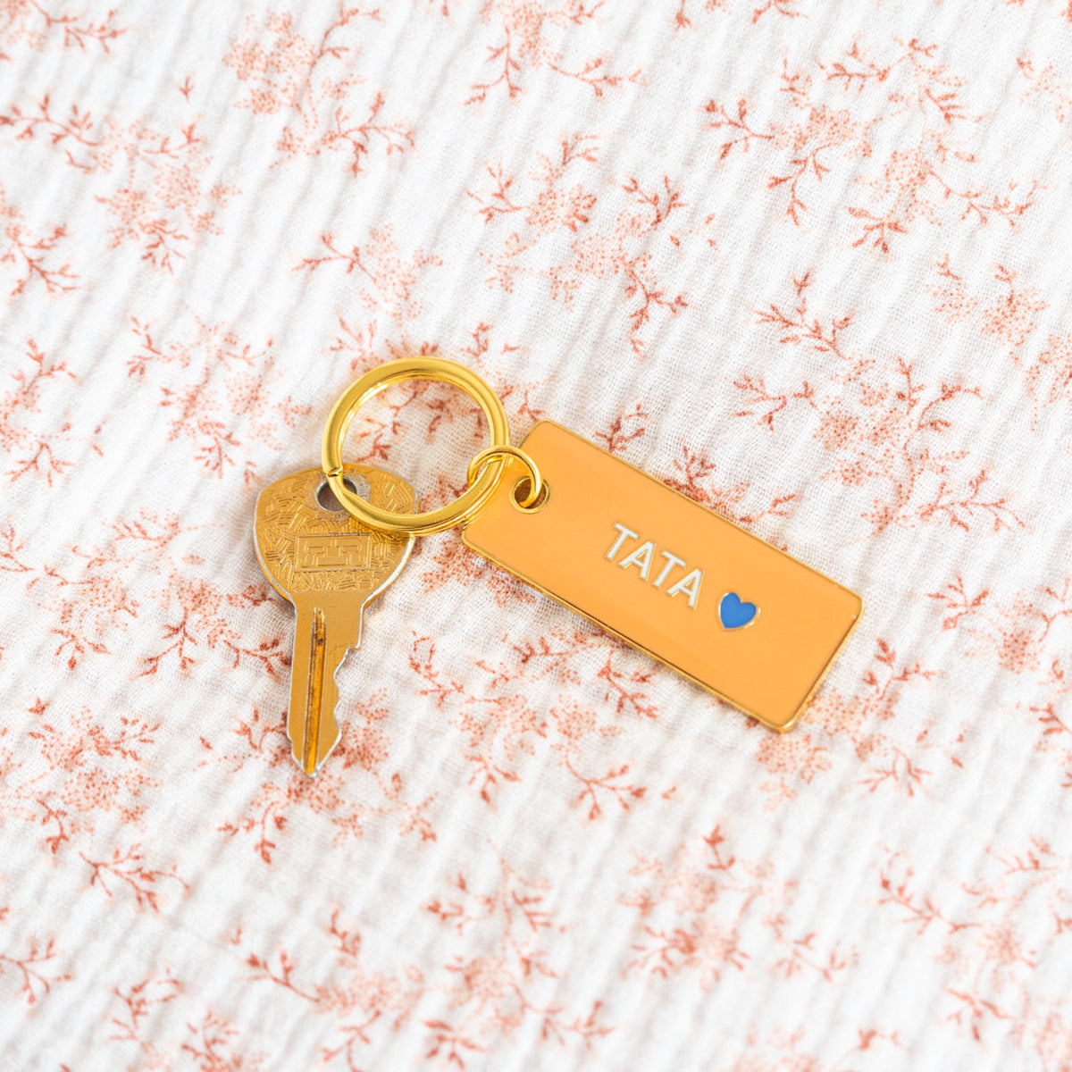 Porte-clé Tata avec un design coloré et un cœur stylisé.