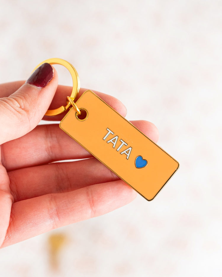 Porte-clé Tata avec un design coloré et un cœur stylisé.