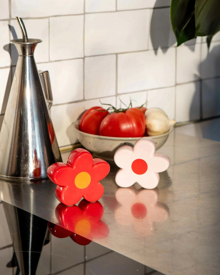 Salière et poivrière en céramique, motif floral en détail.