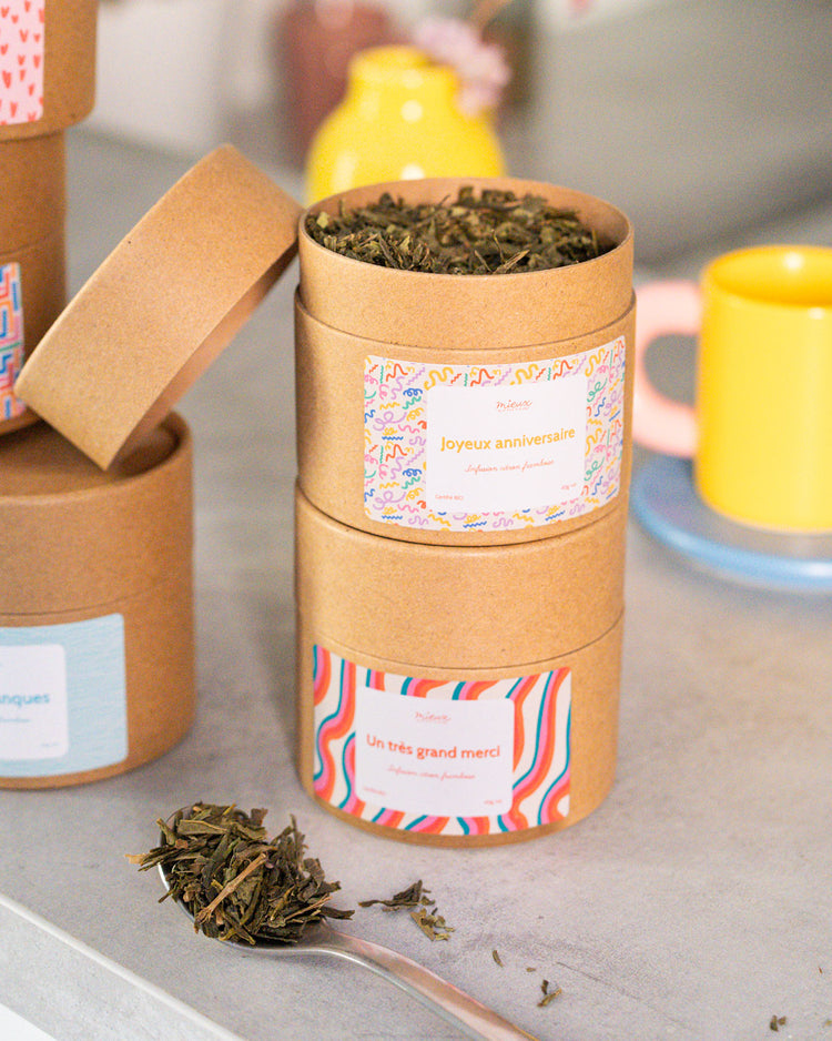 Boîte de thé avec message, vue de face et étiquette colorée.