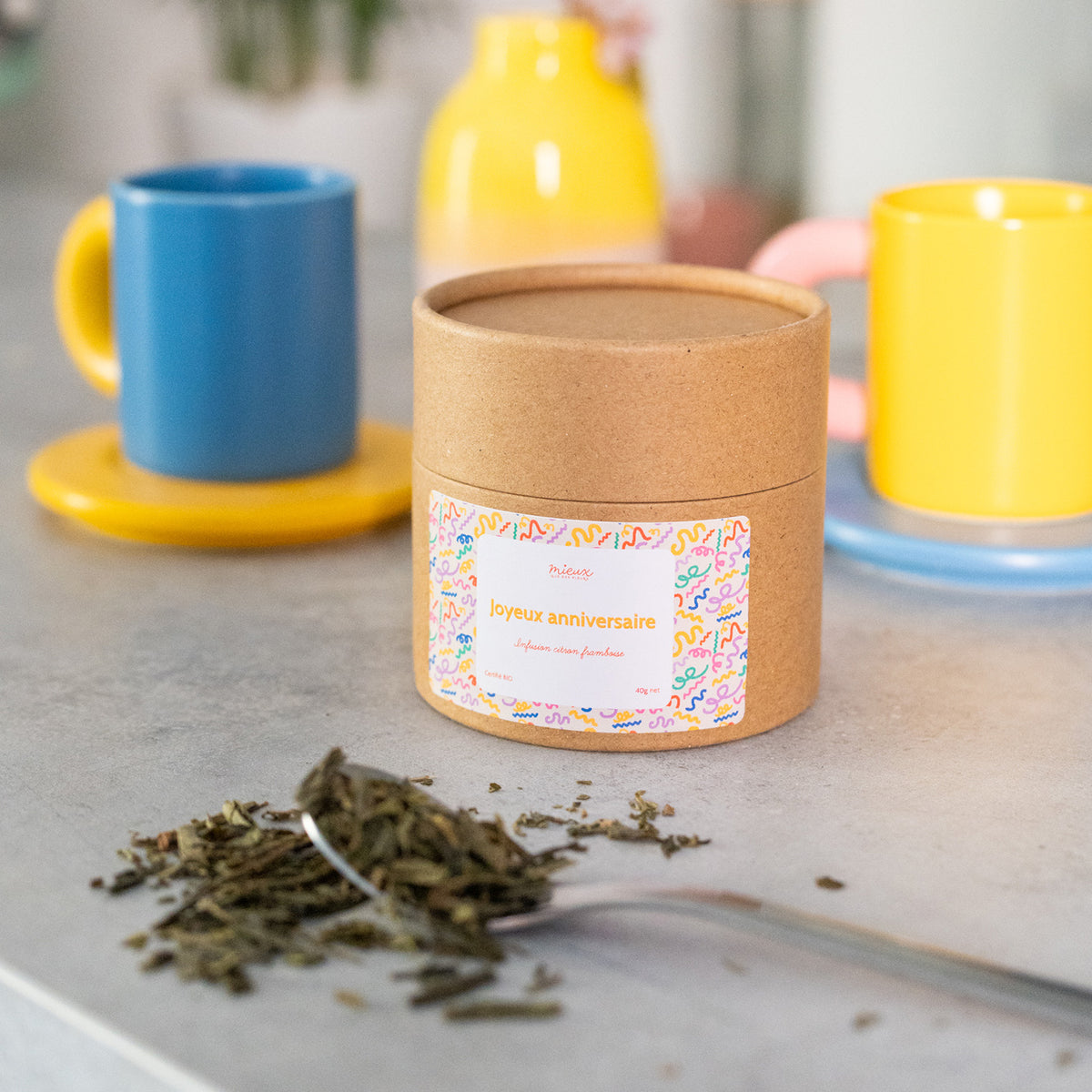 Boîte de thé avec message, vue de face et étiquette colorée.