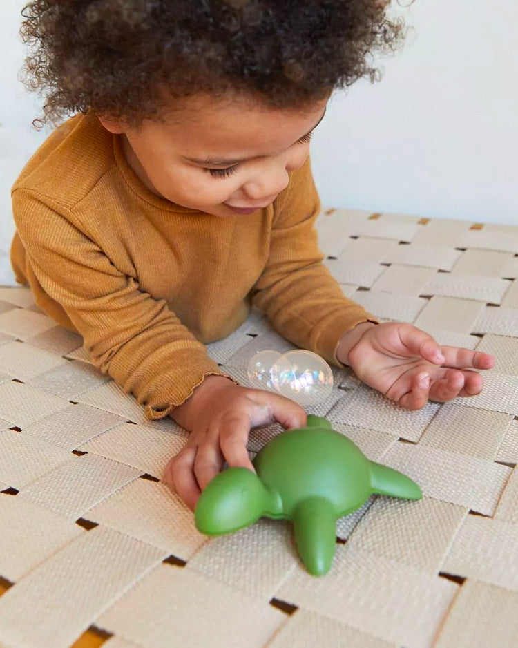 Tortue de bain en filets recyclés, vue de côté avec texture détaillée.