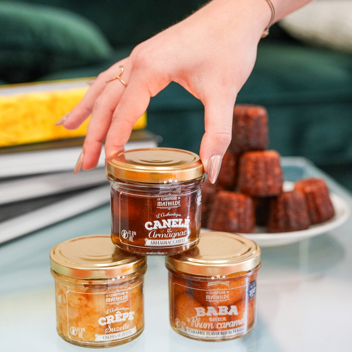 Coffret de desserts avec baba, canelé et crêpes en vue de dessus.
