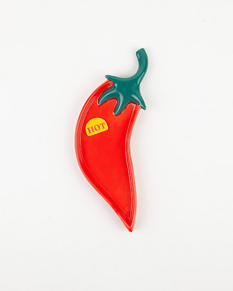 Repose cuillère en forme de piment sur fond blanc