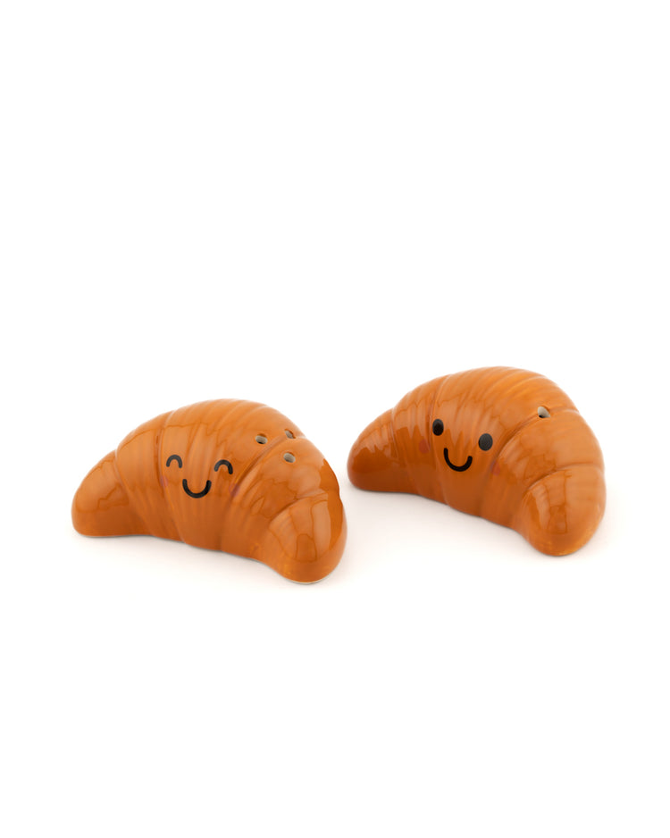 Salière et poivrière en forme de croissants sur fond clair