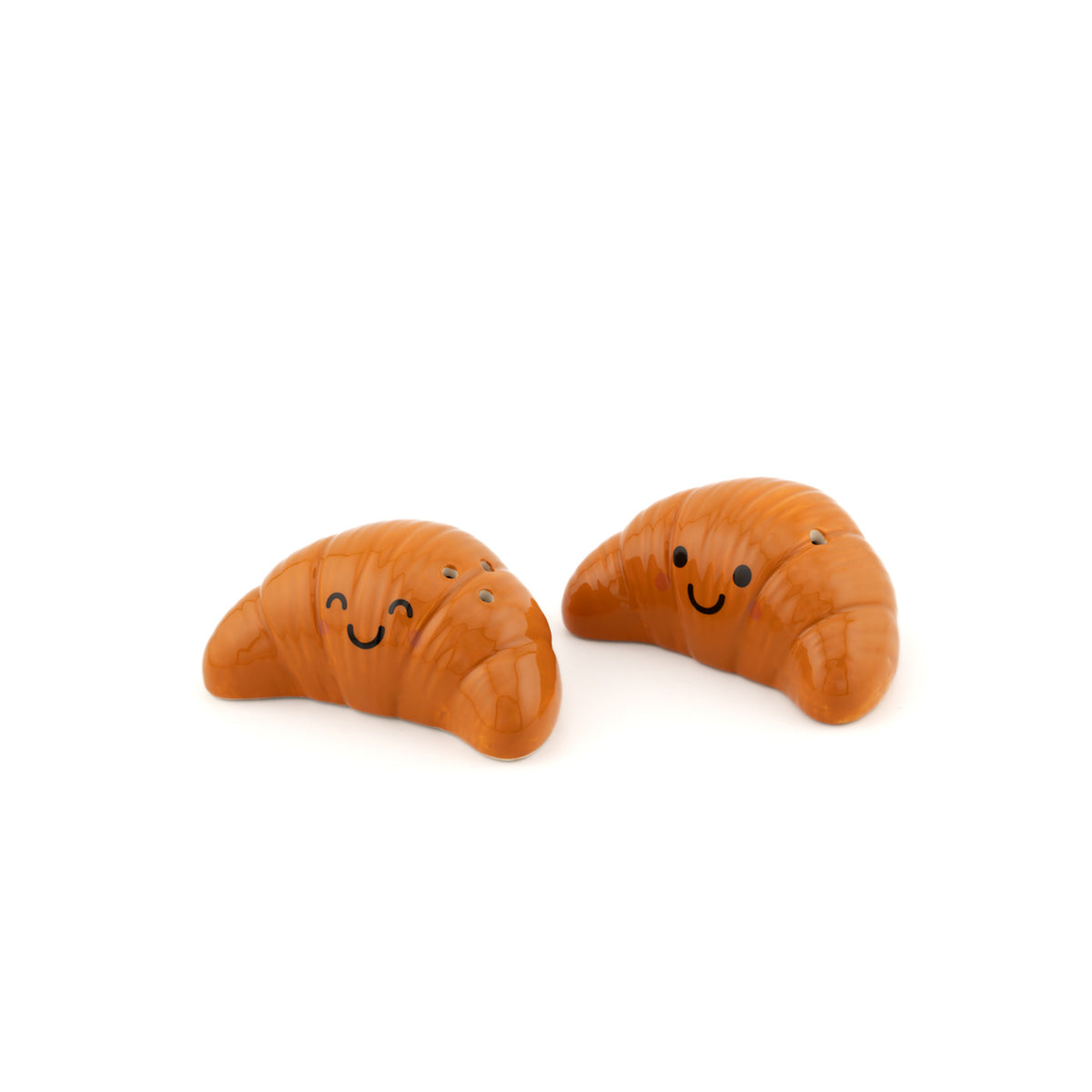 Salière et poivrière en forme de croissants sur fond clair