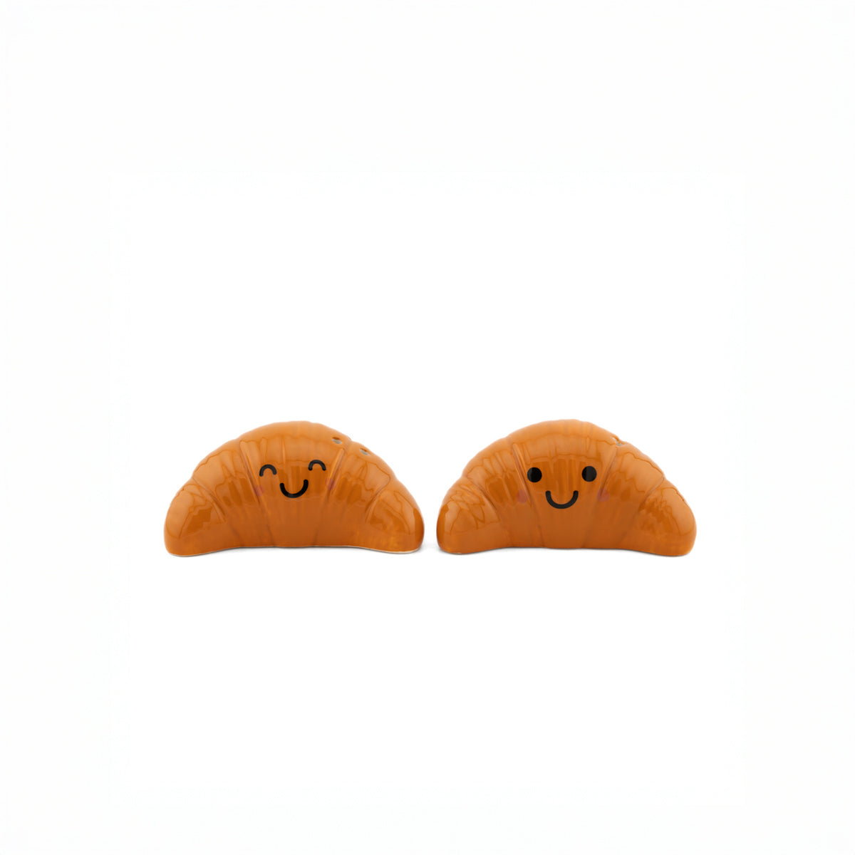 Salière et poivrière en forme de croissants sur fond clair