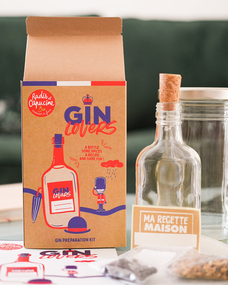 Kit DIY pour gin avec ingrédients et accessoires sur fond blanc.