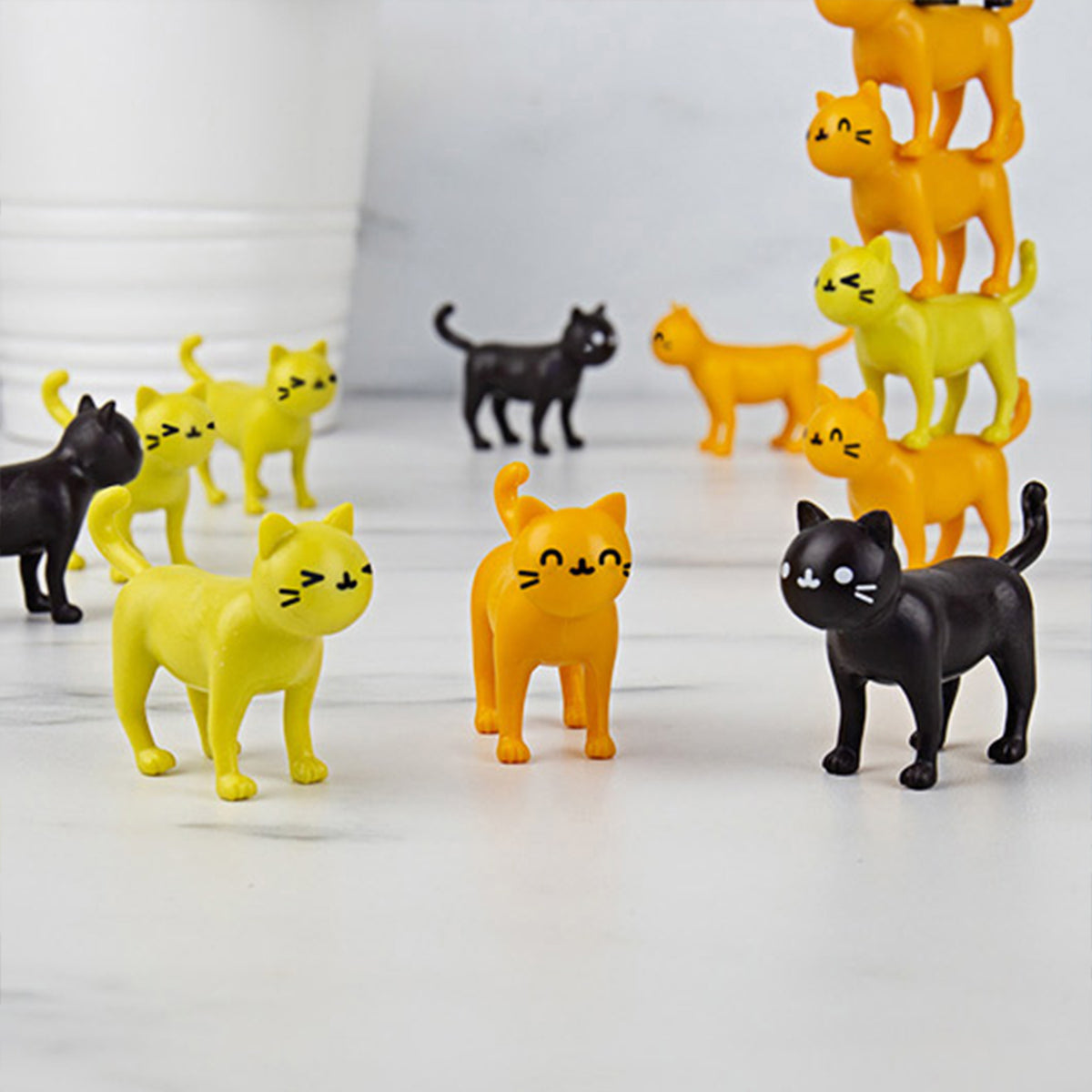 Jeu d'équilibre avec des chats colorés empilés en hauteur.