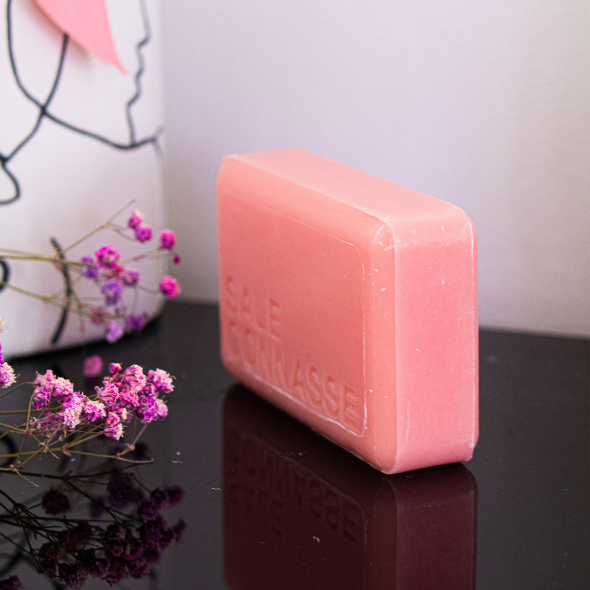 Savon humoristique avec étiquette colorée et motif rose.