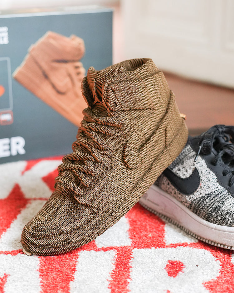 Sculpture en carton de sneakers vue de côté, détails des lacets.